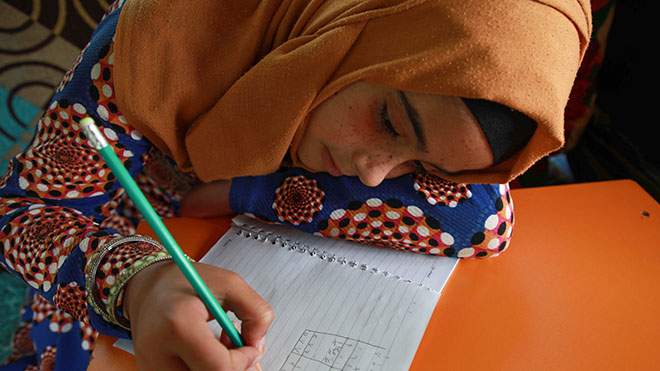 فتيات سوريات نازحات يأخذن دروسًا في مادة الرياضيات في حافلة تم تحويلها إلى فصل دراسي
